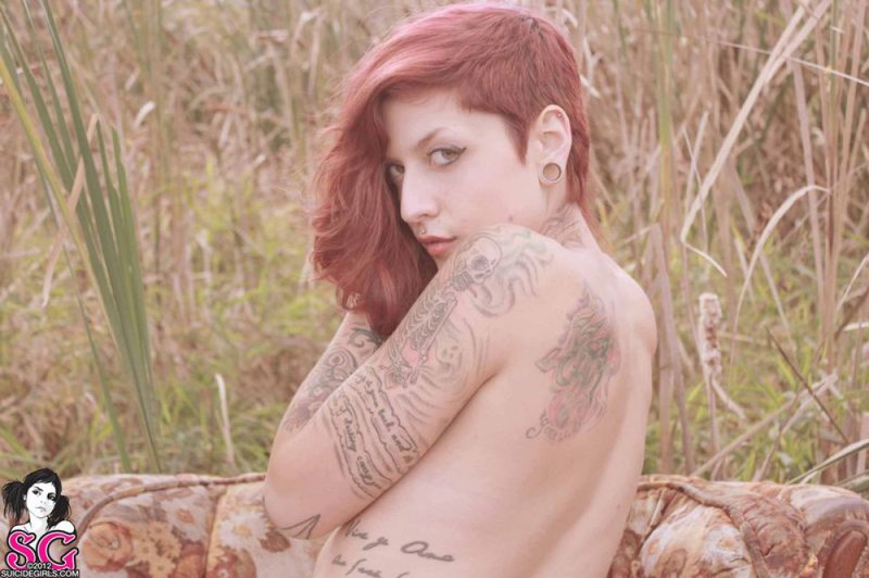 Redhead lusty babe in a tattoo posing on country meadow 4 photo