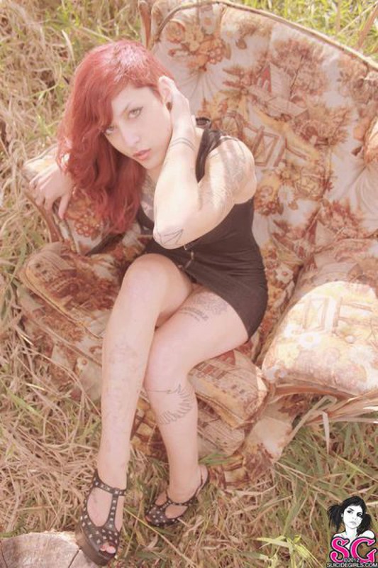 Redhead lusty babe in a tattoo posing on country meadow 18 photo